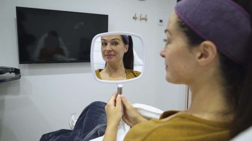 Patient examining skin texture during treatment at Berkshire Aesthetics
